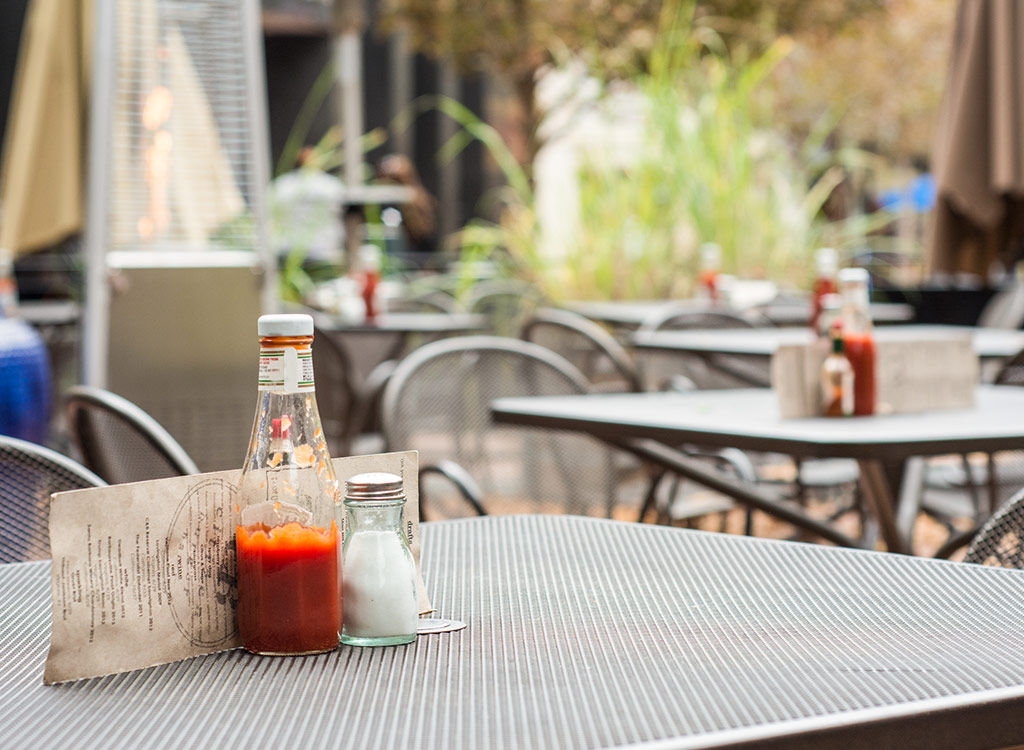 Ketchup glass bottle on table at restaurant