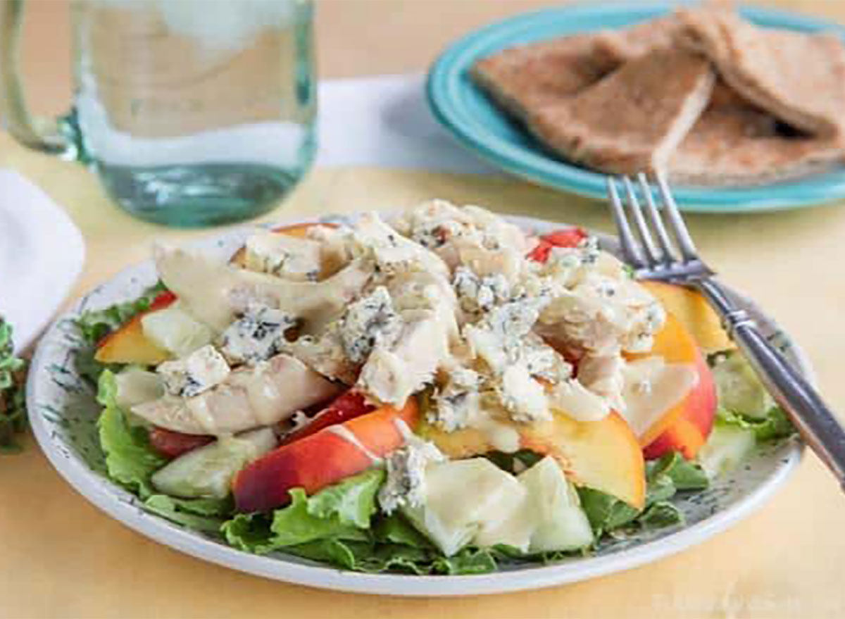 peach tomato chicken blue cheese salad on plate with fork and bread