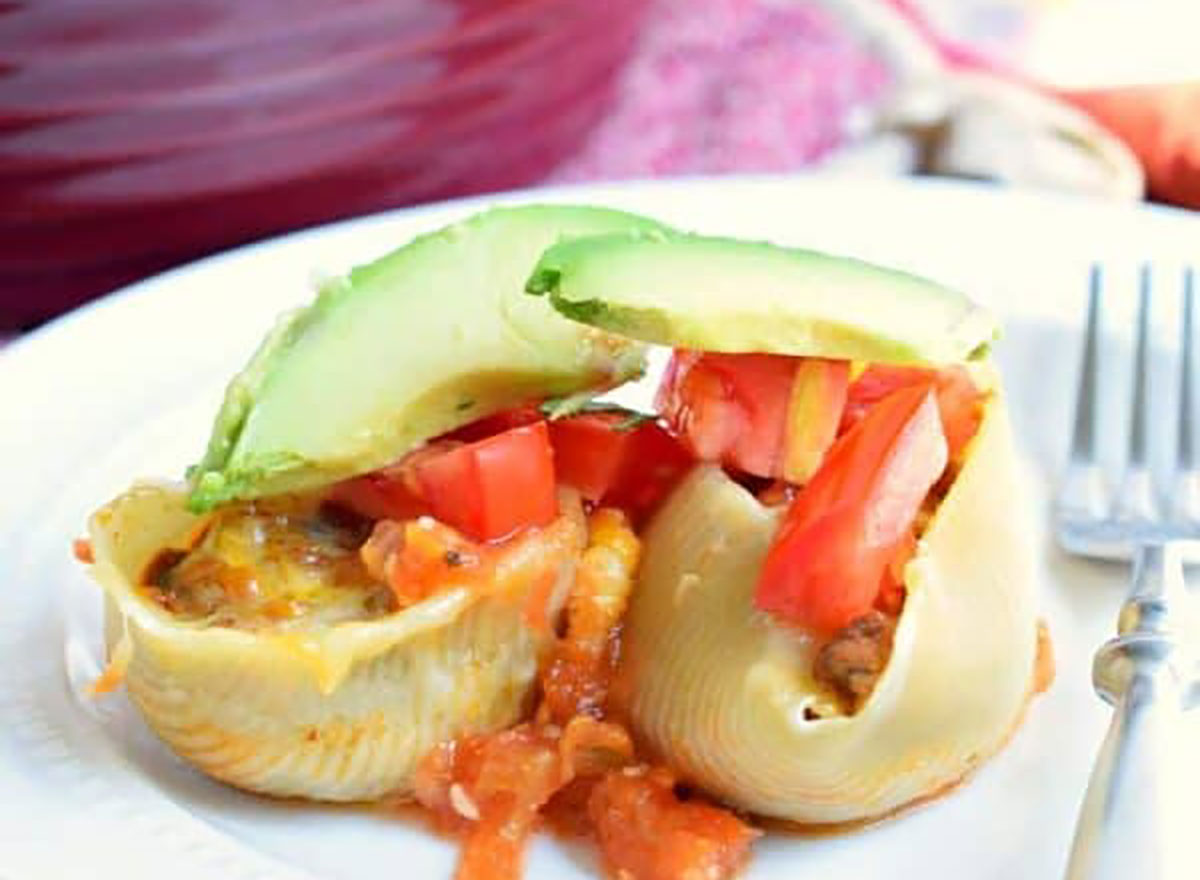 stuffed taco shells with avocado on white plate