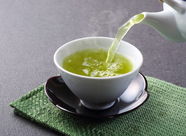 green tea being poured into cup