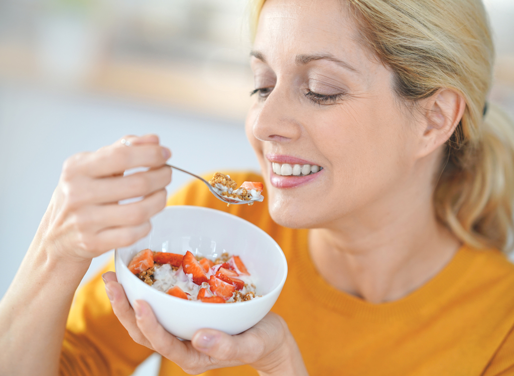 Woman eating breakfast yogurt