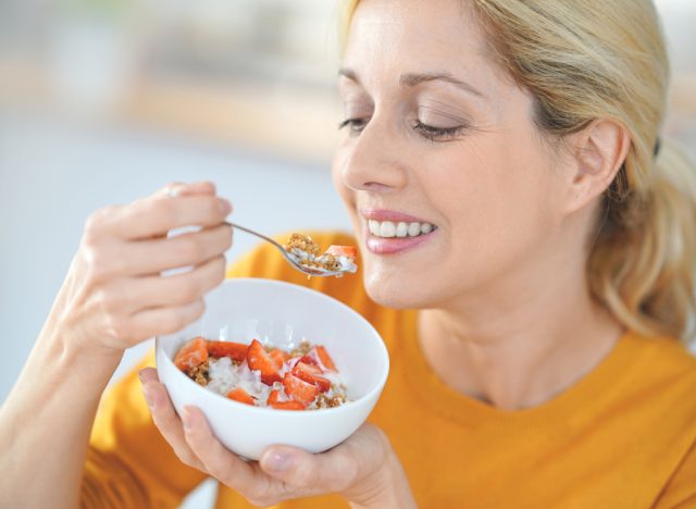 Woman eating breakfast yogurt