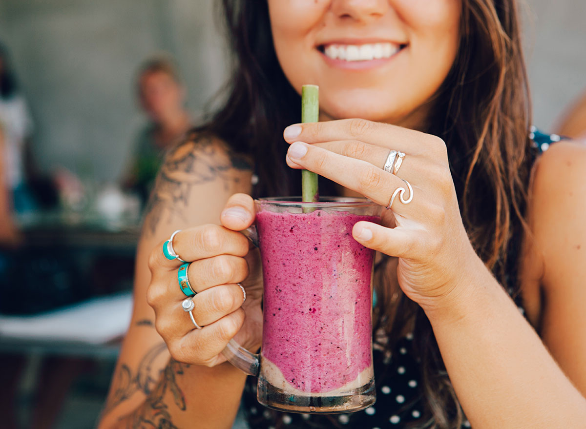 girl holding smoothie at bar