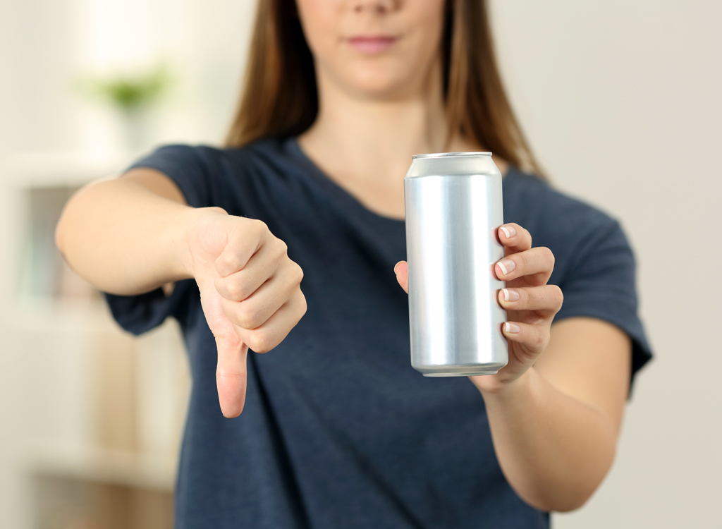 Woman thumbs down saying no to drinking soda