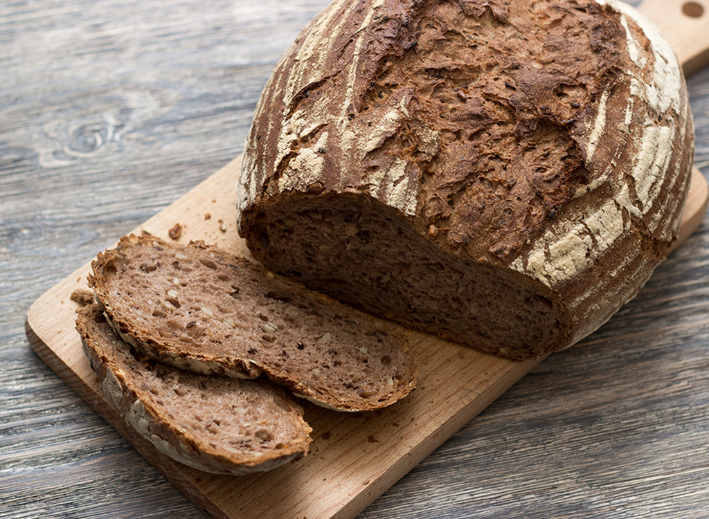 loaf of crusty brown bread on cutting board