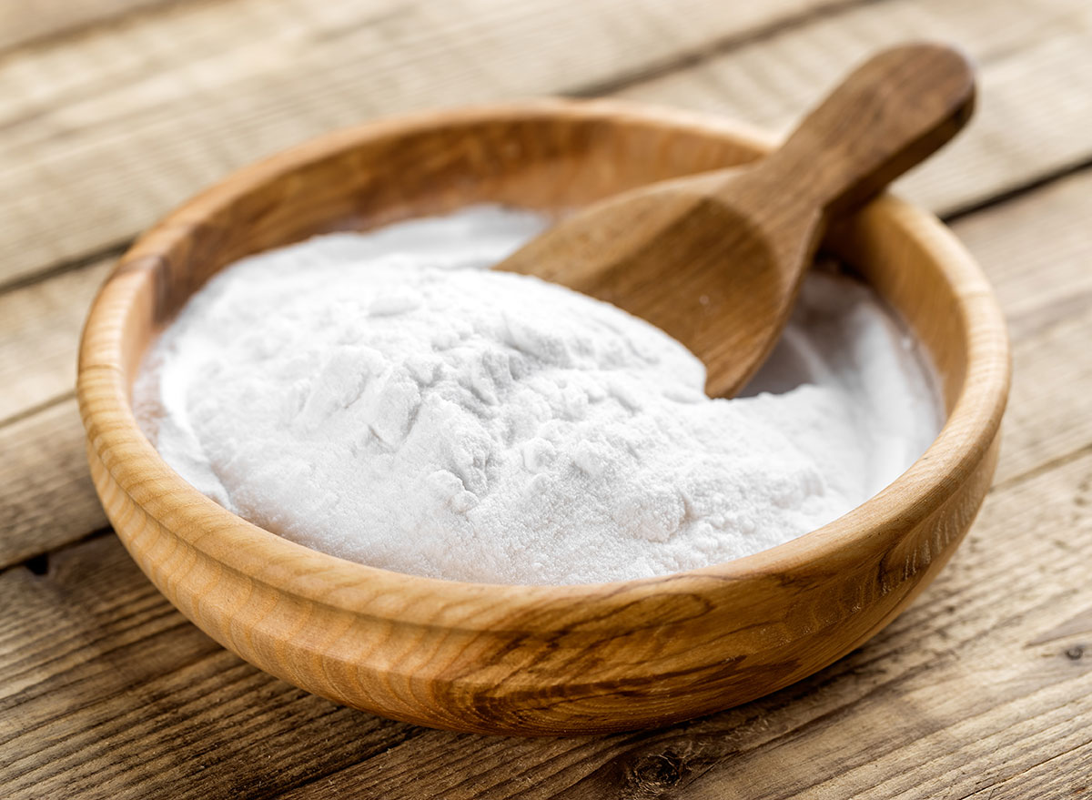 Baking soda in a wooden bowl with a wooden spoon