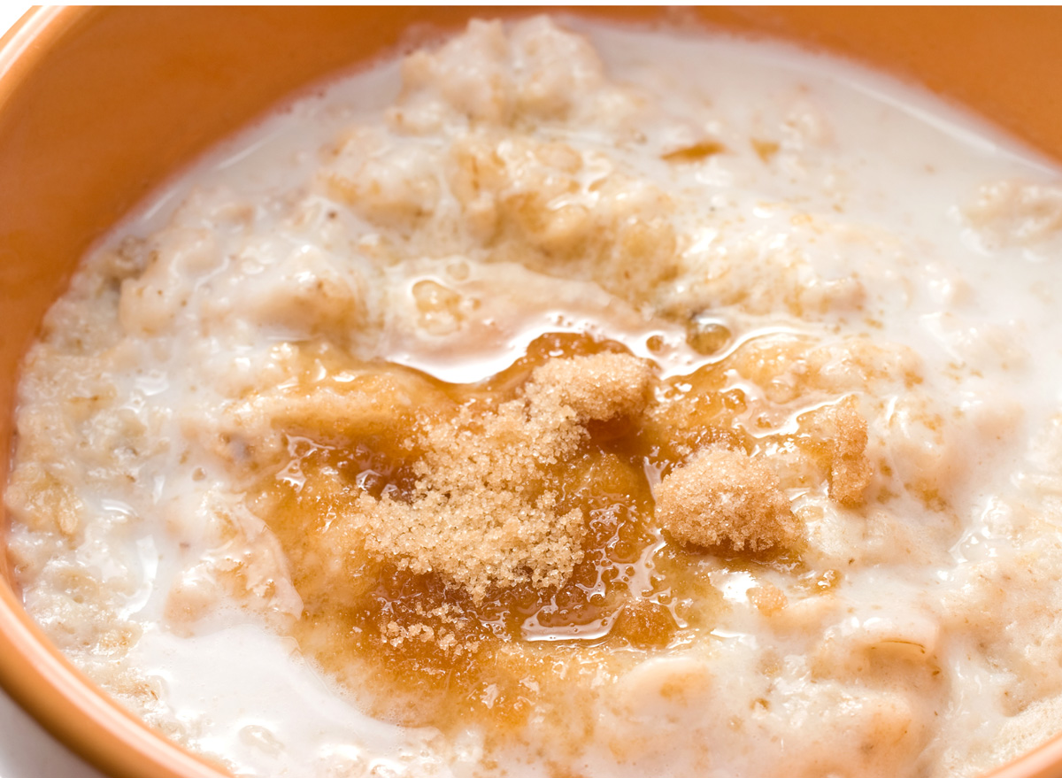Bowl of oatmeal with brown refined sugar and milk