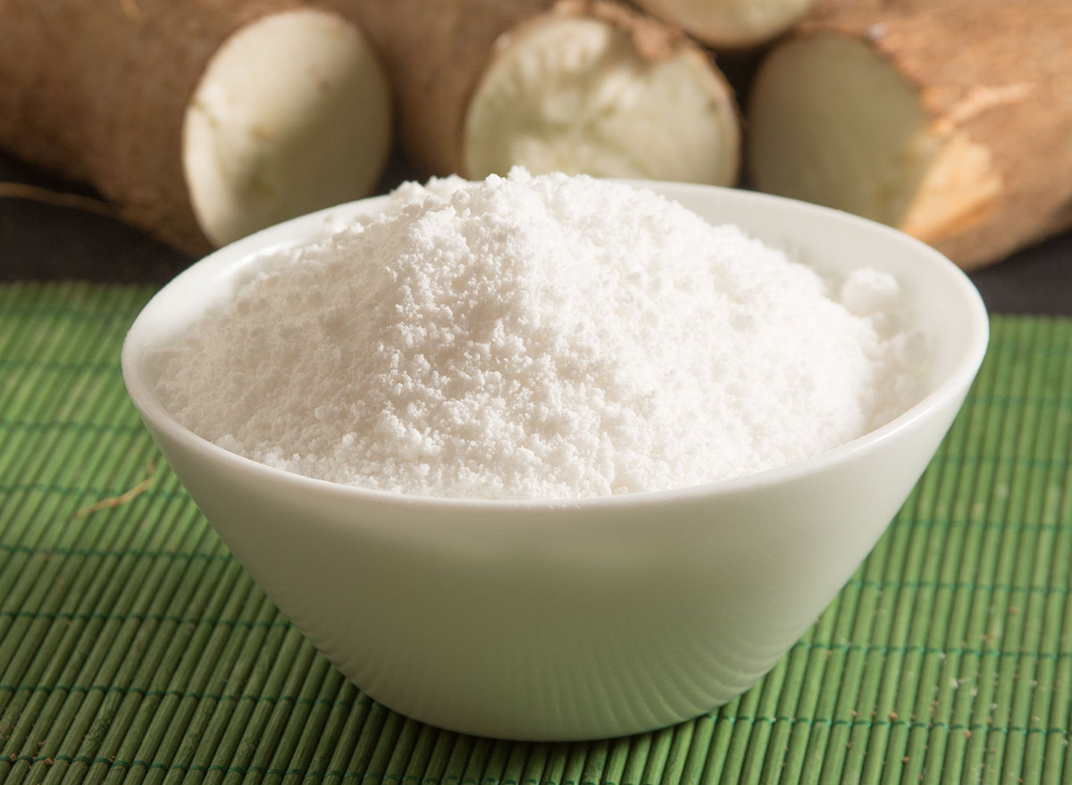 Cassava flour in bowl with roots