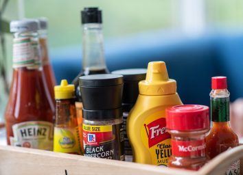 basket of condiments ketchup hot sauce mustard