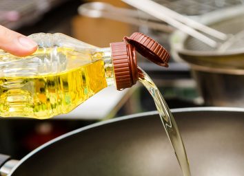 Pouring canola oil into pan