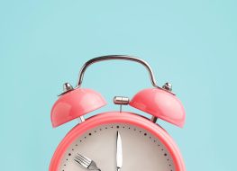 pink alarm clock on blue background