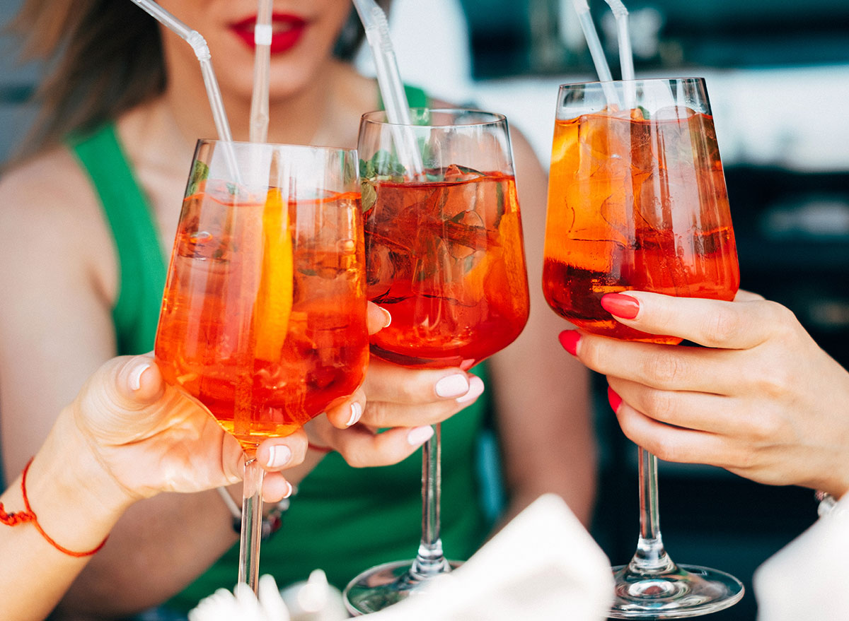 women holding aperol spritz cocktails