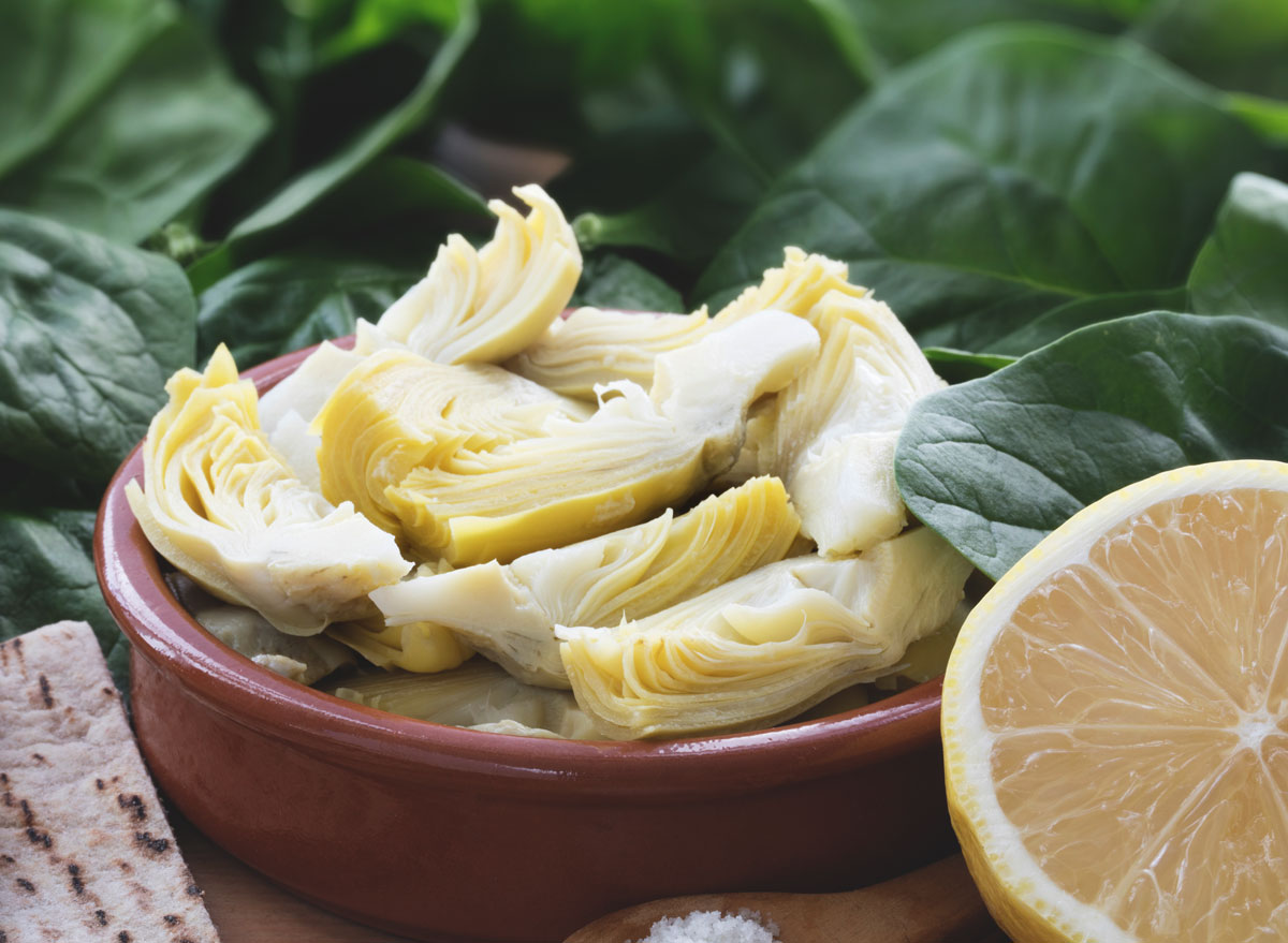 Artichoke hearts in bowl with half lemon - endometriosis diet