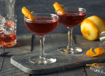boulevardier cocktail in tall glass with orange peel garnish