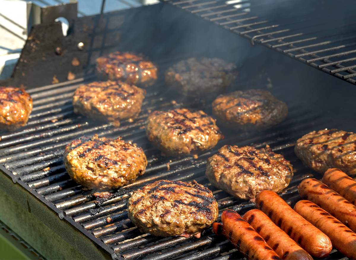 multiple burger patties and hot dogs on grill