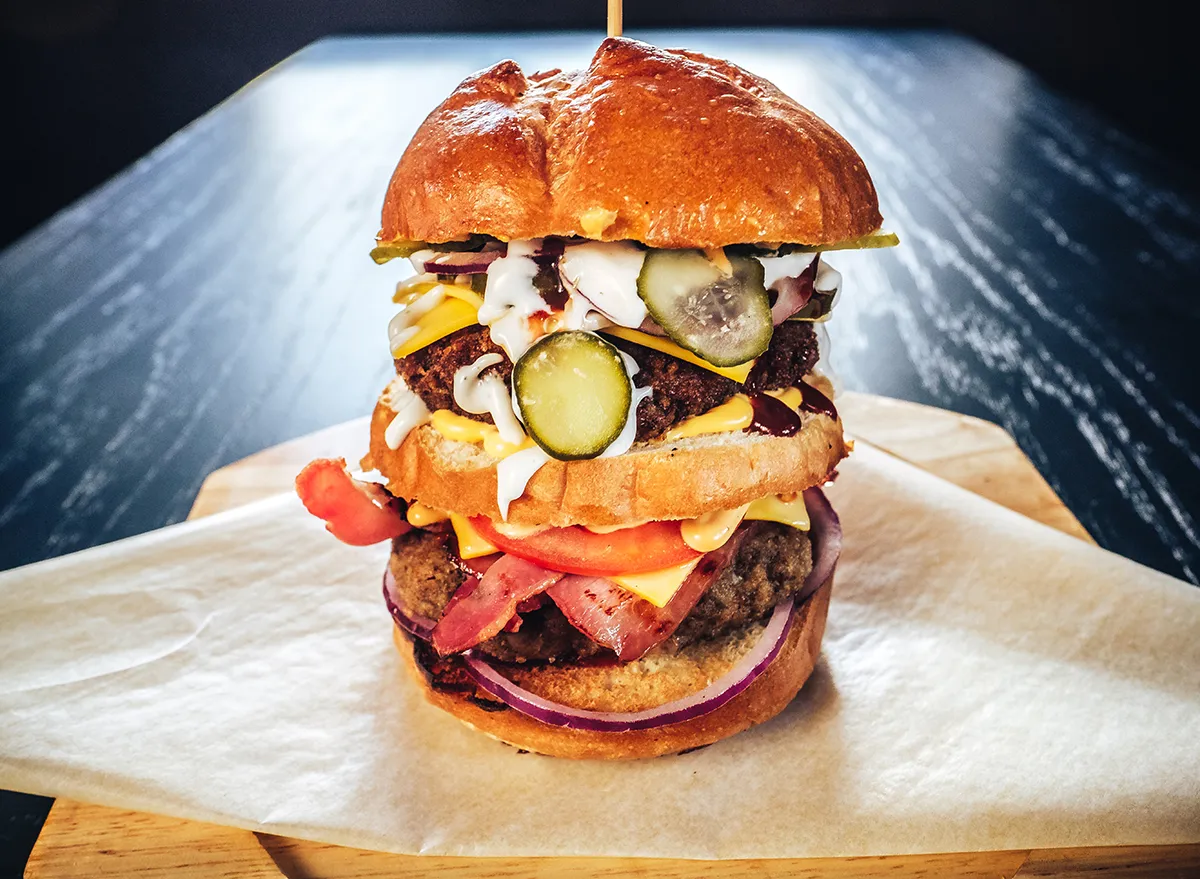 huge burger with multiple layers of toppings