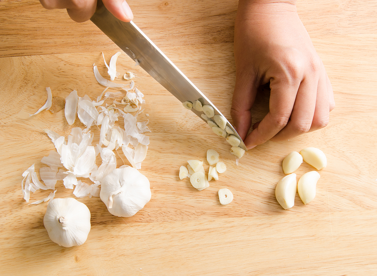 woman-chopping-garlic-on-cutting-board