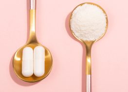 collagen pills and powder on gold spoons pink background