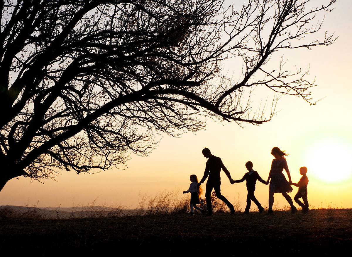 family with kids walking at sunset