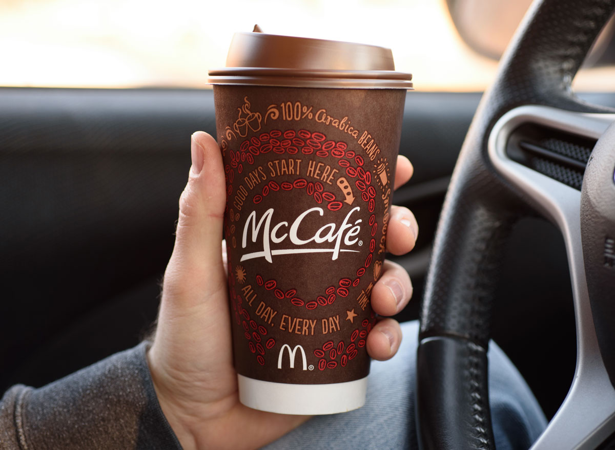 Man holding mccafe coffee cup from mcdonalds in car