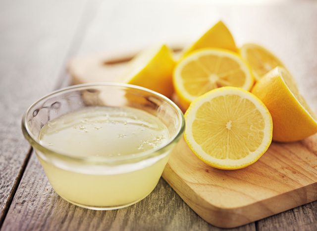 lemon juice in bowl next to sliced lemons