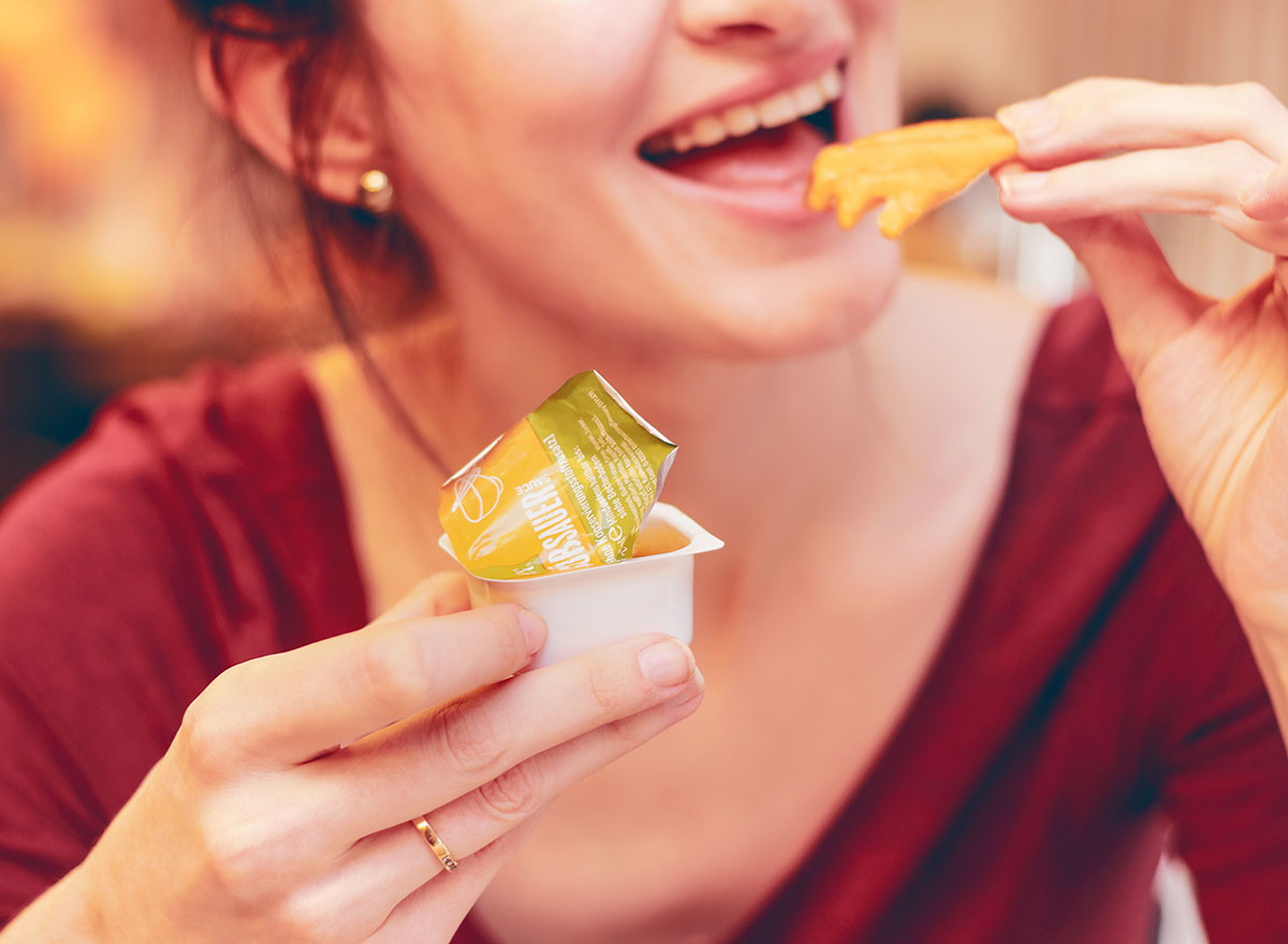 girl eating fries with dipping sauce