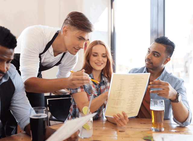 server making a suggestion to couple about menu