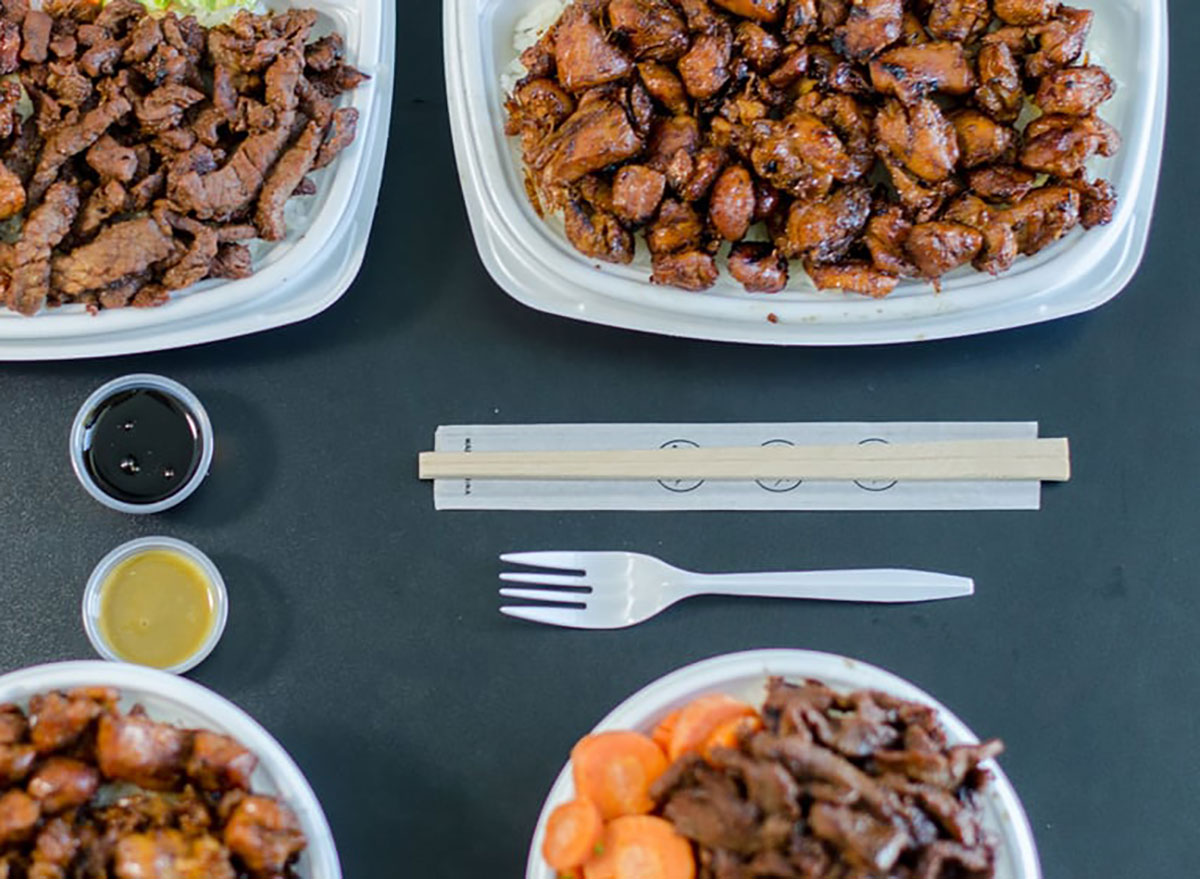 plates of meat from the flame broiler with plastic fork and dipping sauces