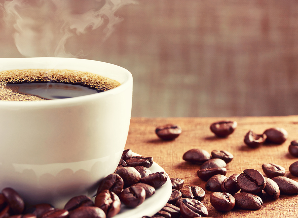 hot-mug-of-coffee-with-coffee-beans-scattered-around-it