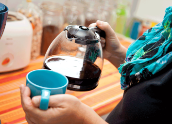 woman holding coffee pot and mug