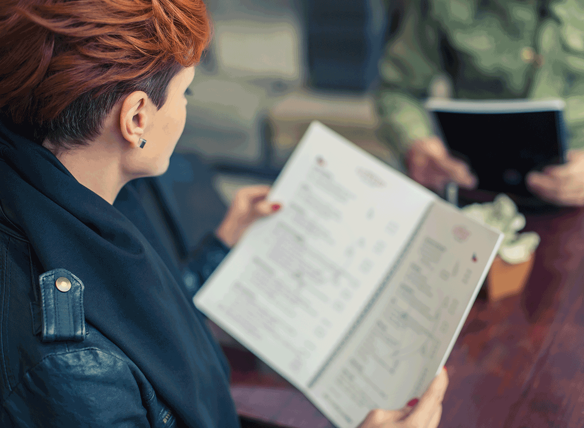 woman looking over menu outside