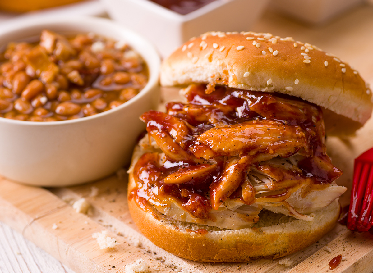 BBQ pork sandwich with a cup of beans