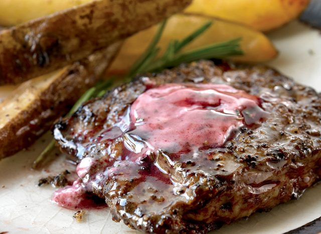 grilled steak topped with red wine butter next to steak fries