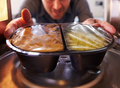 man microwaving frozen meal