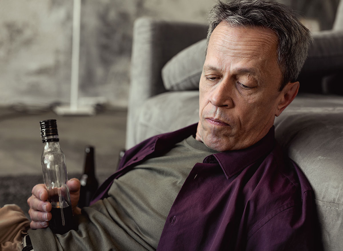 man staring with liquor bottle in hand - how does alcohol affect the brain