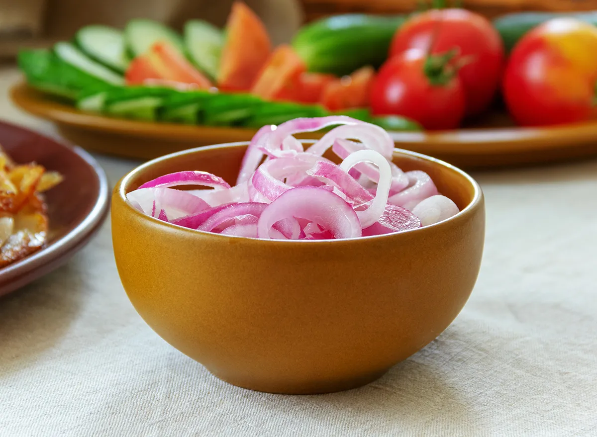 pickled red onion in a light brown ceramic bowl