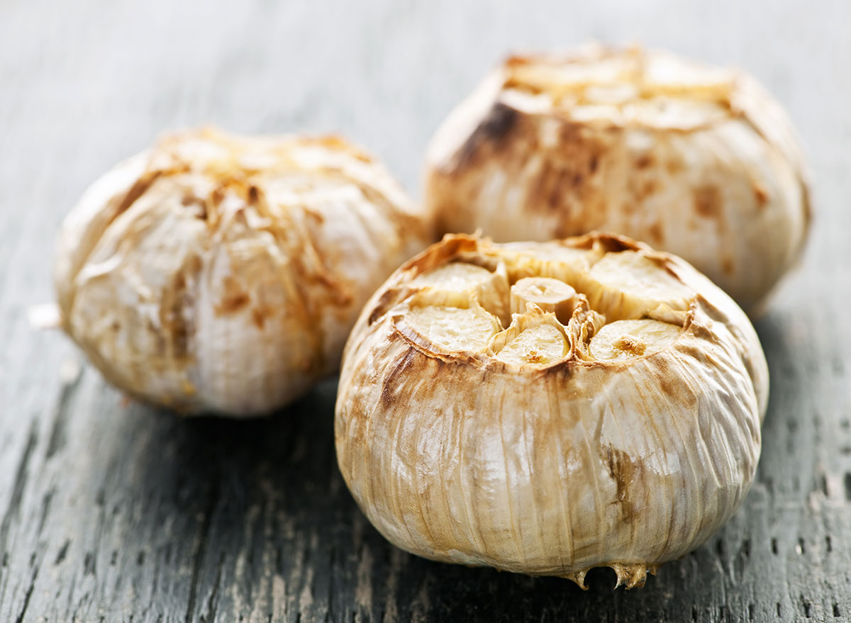 three cloves of roasted garlic on table