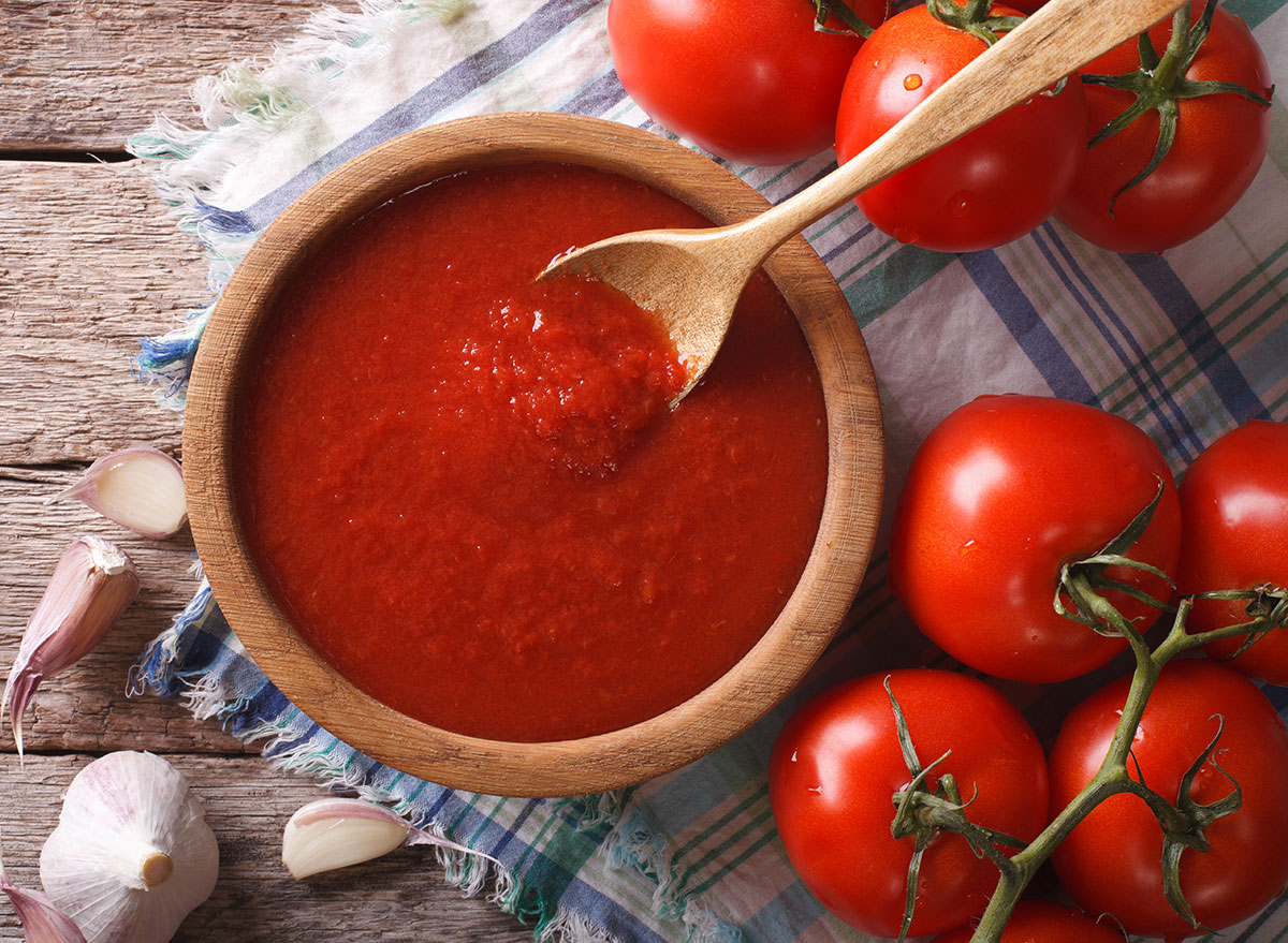 tomato sauce in wooden bowl with wooden spoon