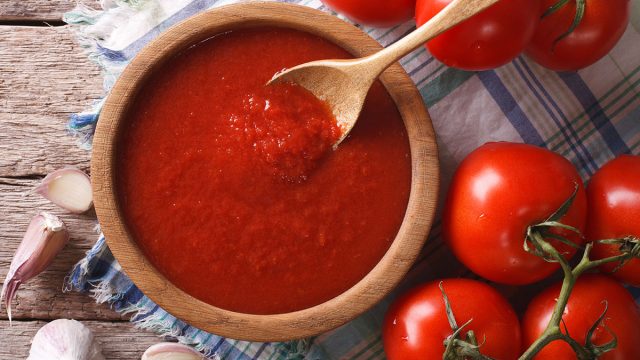 tomato sauce in wooden bowl with wooden spoon