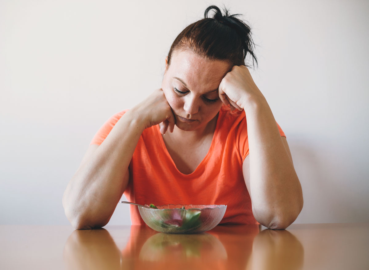 Unhappy woman doesnt want to eat salad or a healthy diet - always hungry reasons