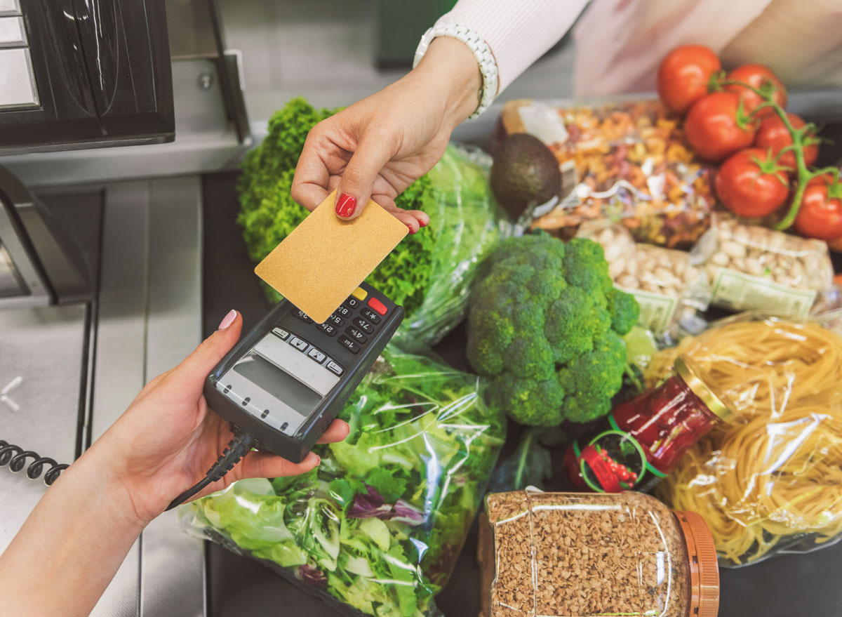 Woman paying for her vegetable vegan groceries at a checkout