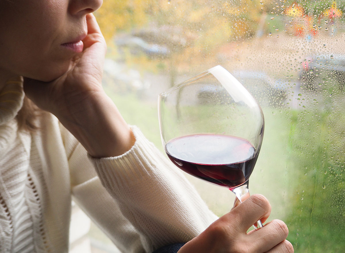 woman drinking wine by window - how does alcohol affect the brain - always hungry reasons