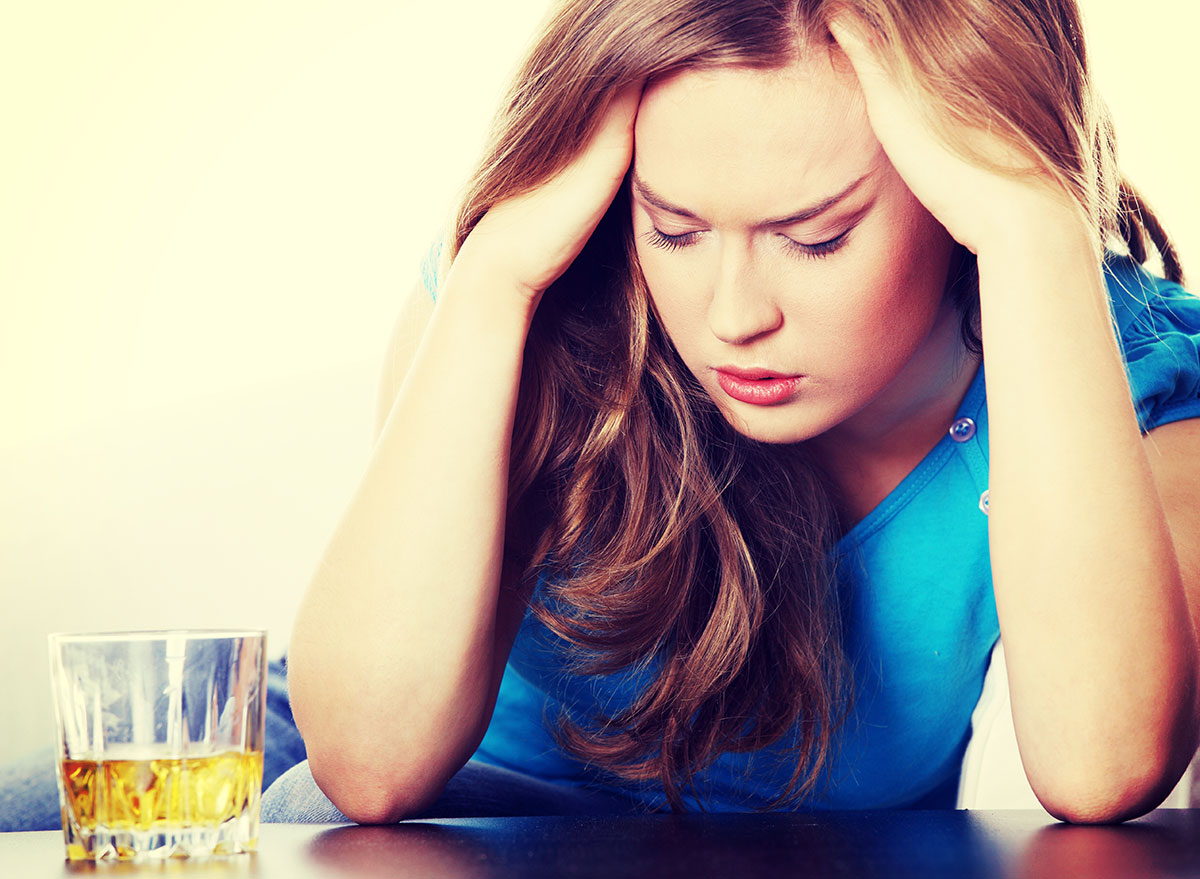 woman holding head from alcohol - how does alcohol affect the brain