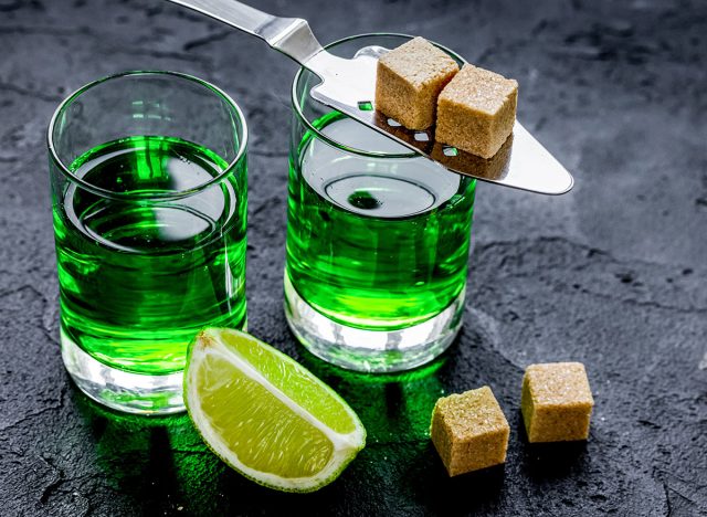 absinthe on spoon with lime green liquid in glass