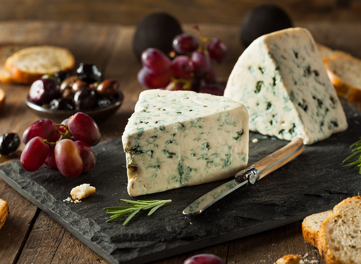 gorgonzola on cheese board with crostinis and purple grapes