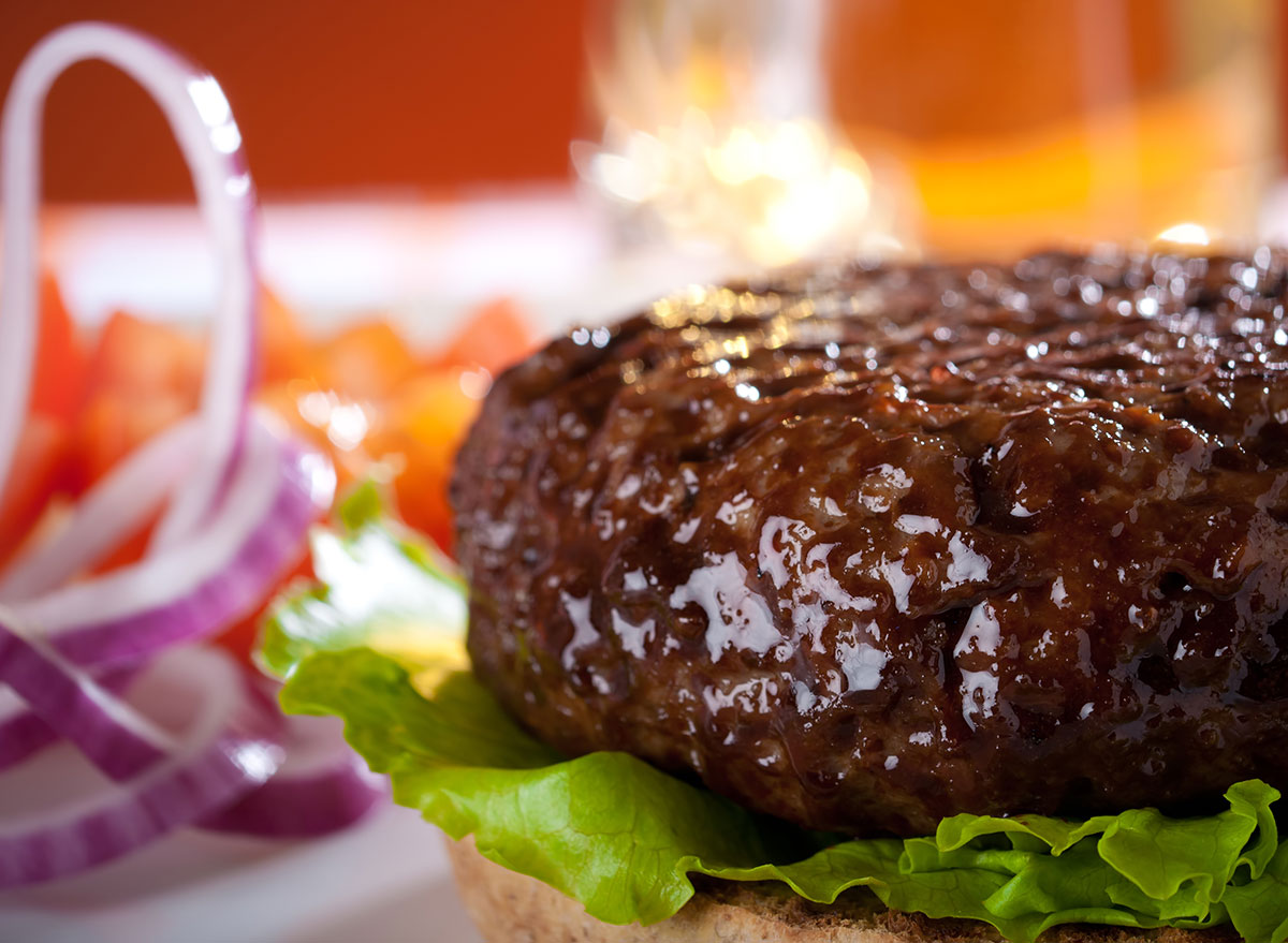 closeup of cooked burger patty on bun with toppings