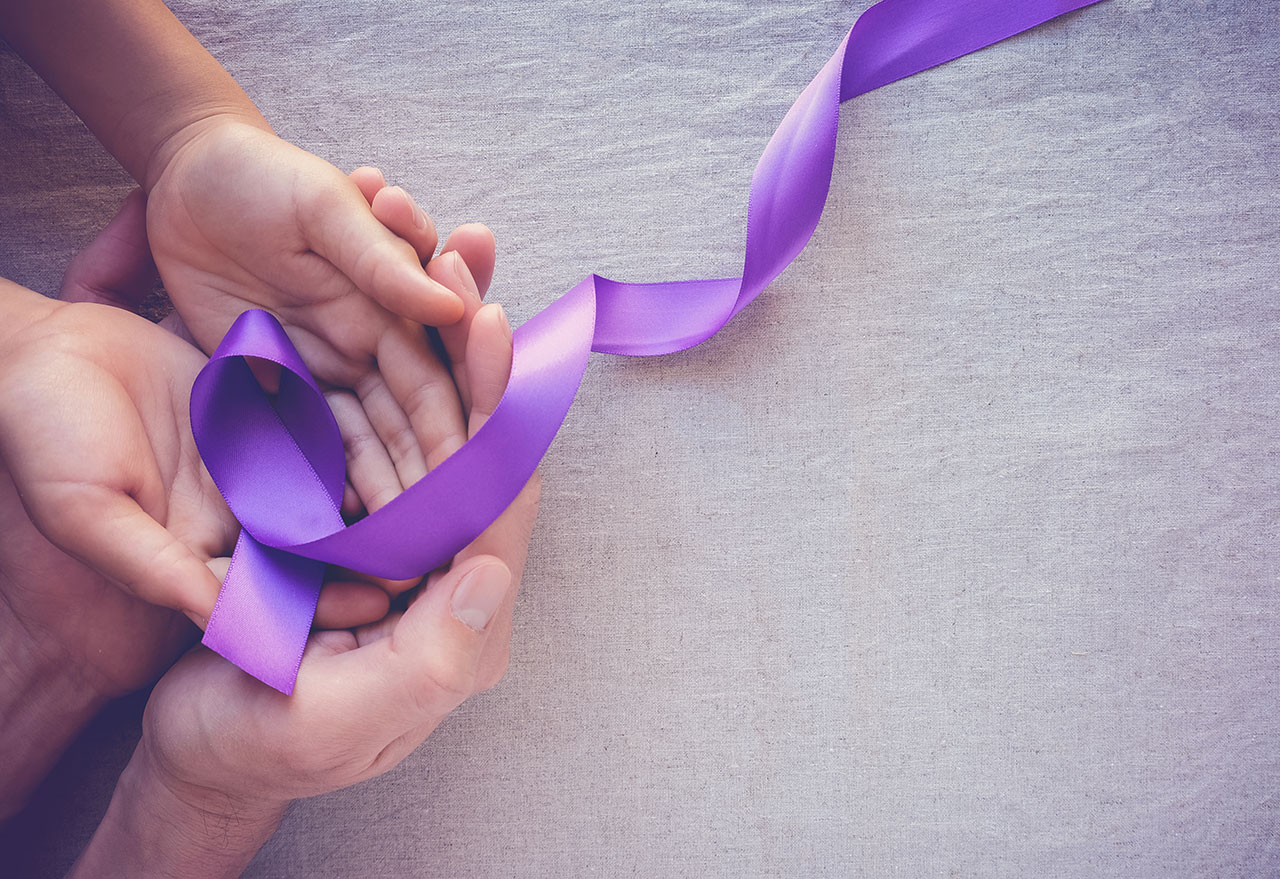 two pairs of hands intertwined with epilepsy awareness ribbon