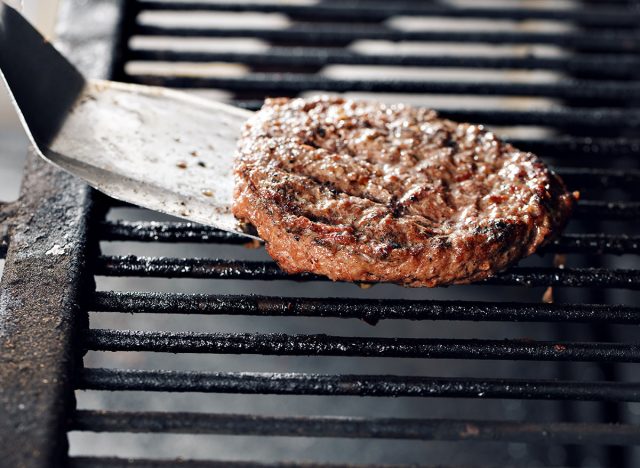 spatula flipping burger patty on grill