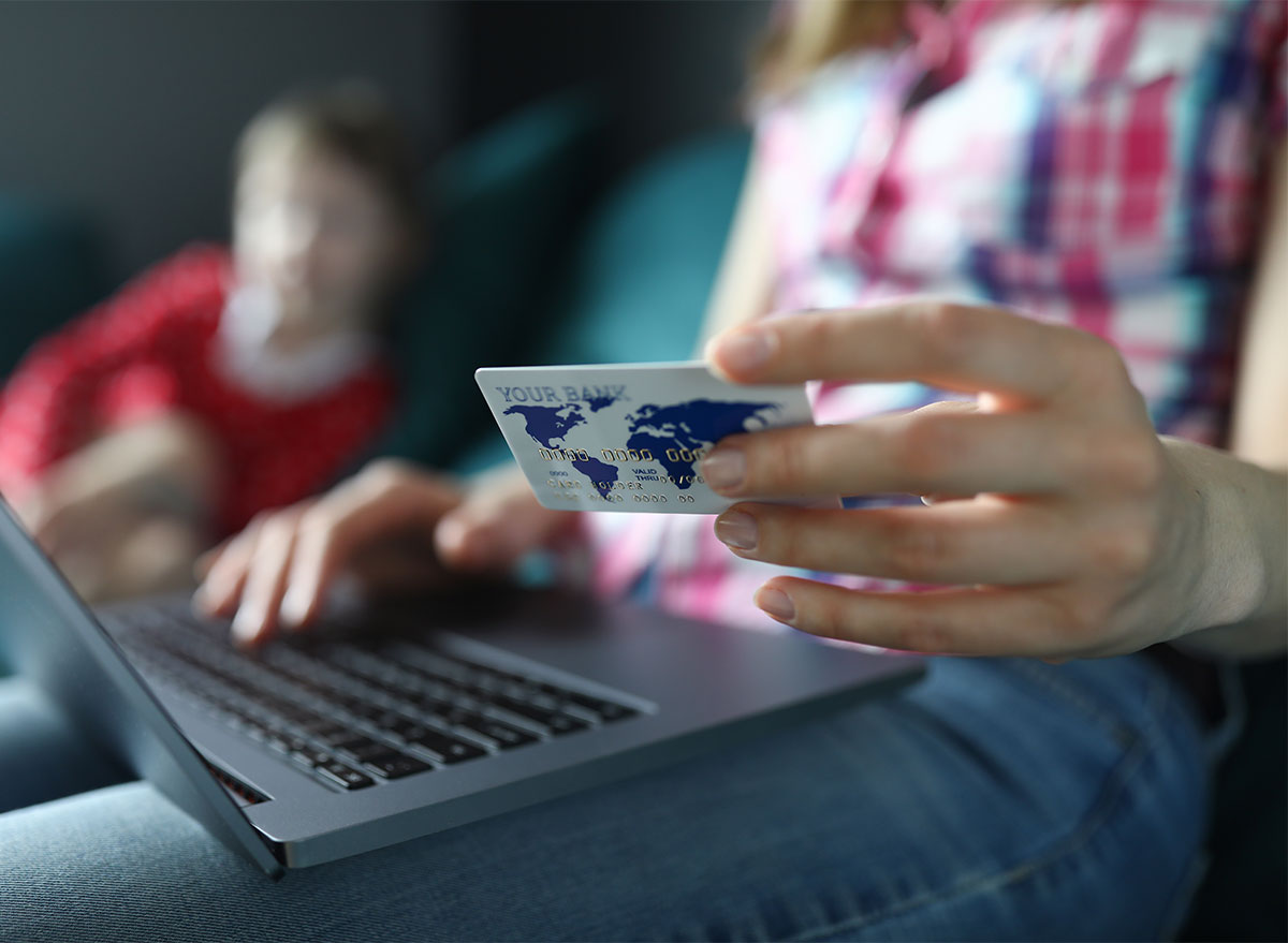 woman holding credit card online shopping laptop