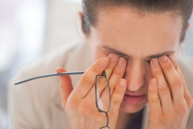 Tired stressed woman rubbing eyes